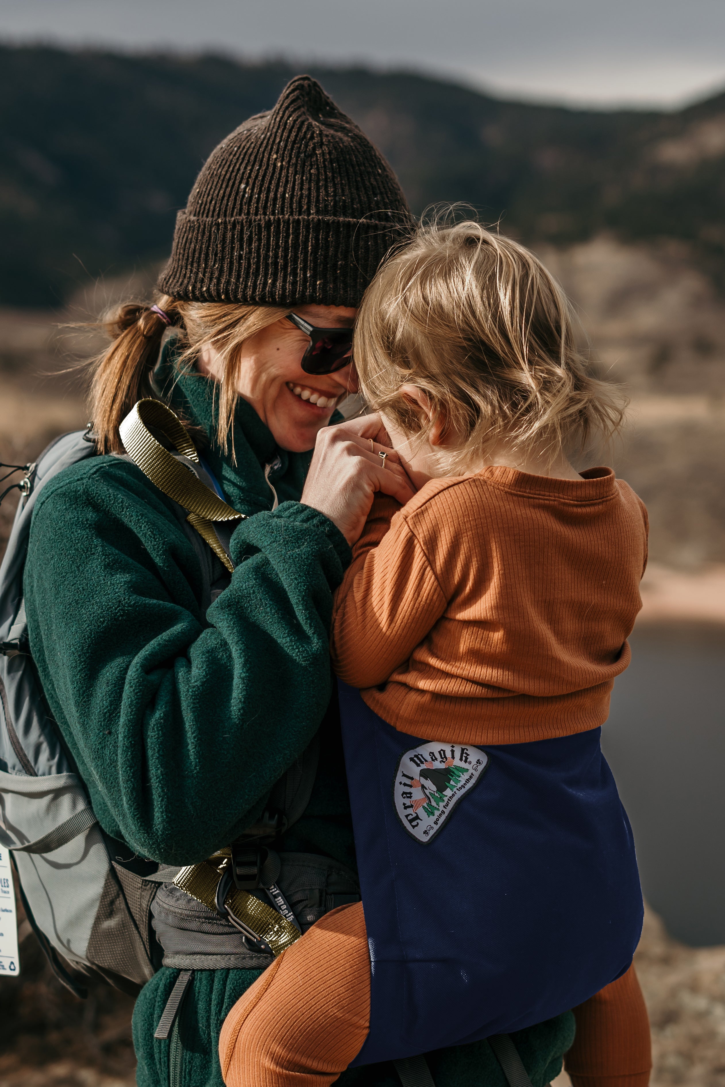 Woman holding a child with a scenic background